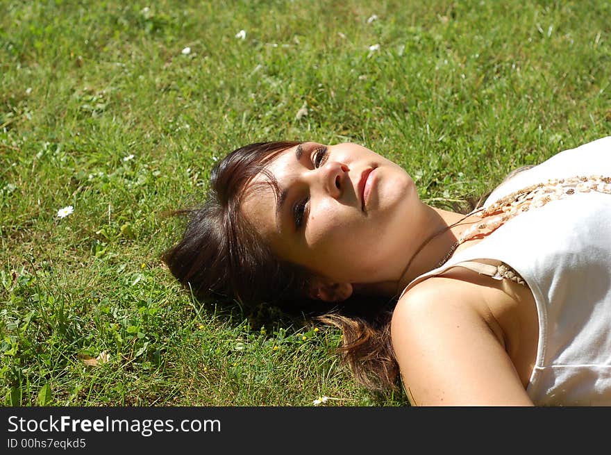 Attractive woman lying and relaxing on green grass. Attractive woman lying and relaxing on green grass