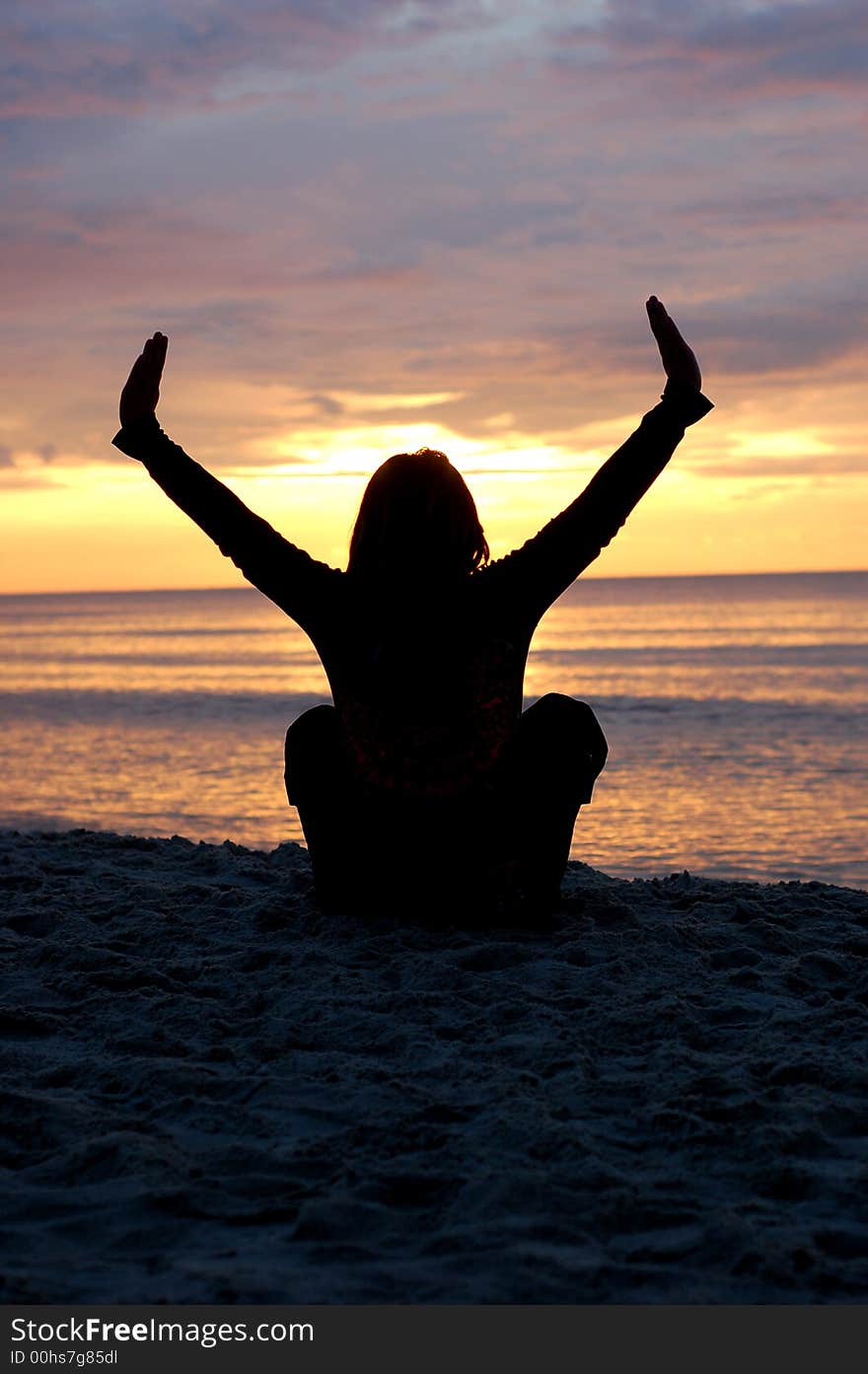 Woman sitting on the beach at sunset. Woman sitting on the beach at sunset