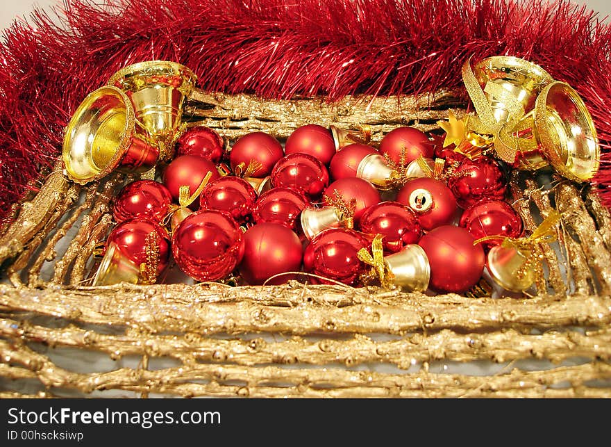 Red Christmas balls and handbells on golden frame with garland