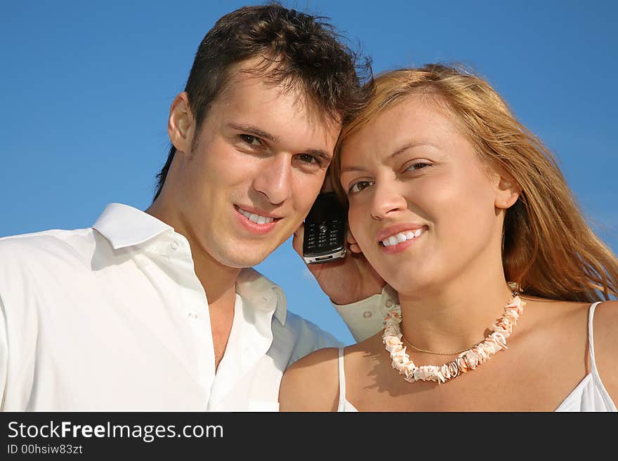 Man, woman and cell phone with blue sky