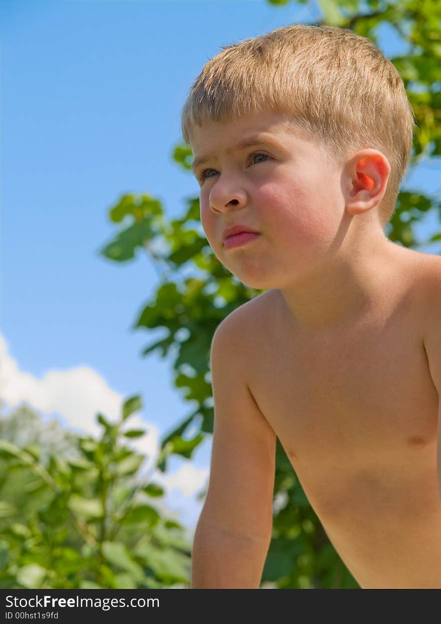 Little boy closeup over green trres and blue sky. Little boy closeup over green trres and blue sky