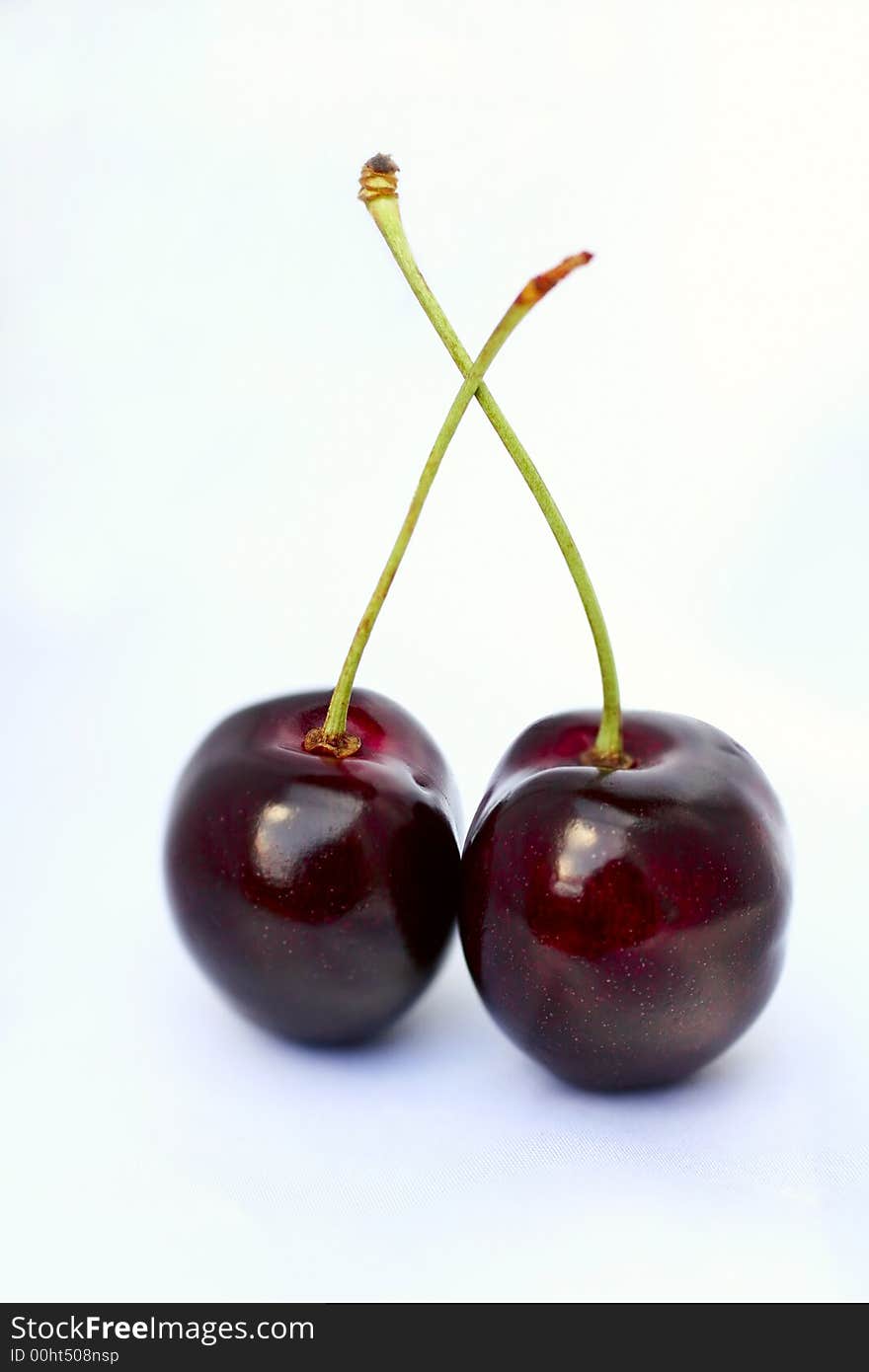 Two deep red cherries on white background. Two deep red cherries on white background