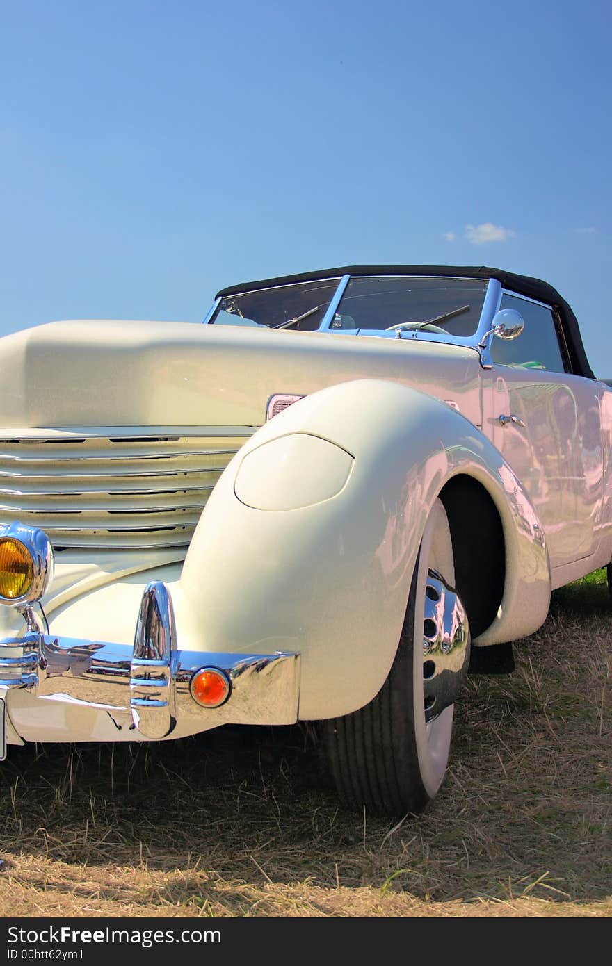 Vintage roadster close-up against a blue sky. Vintage roadster close-up against a blue sky