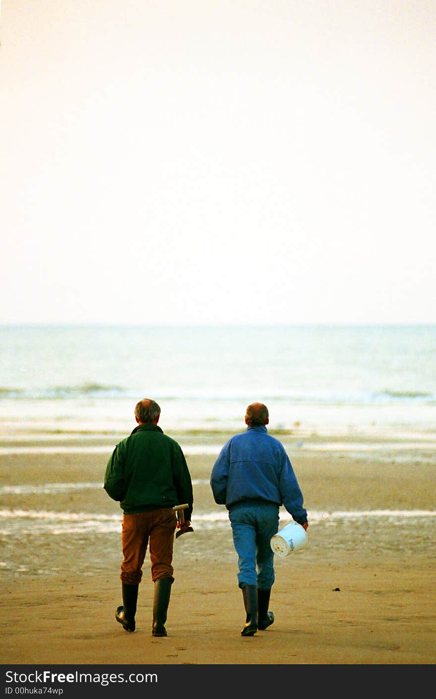 Two guys taking a walk on the beach in winter. Two guys taking a walk on the beach in winter