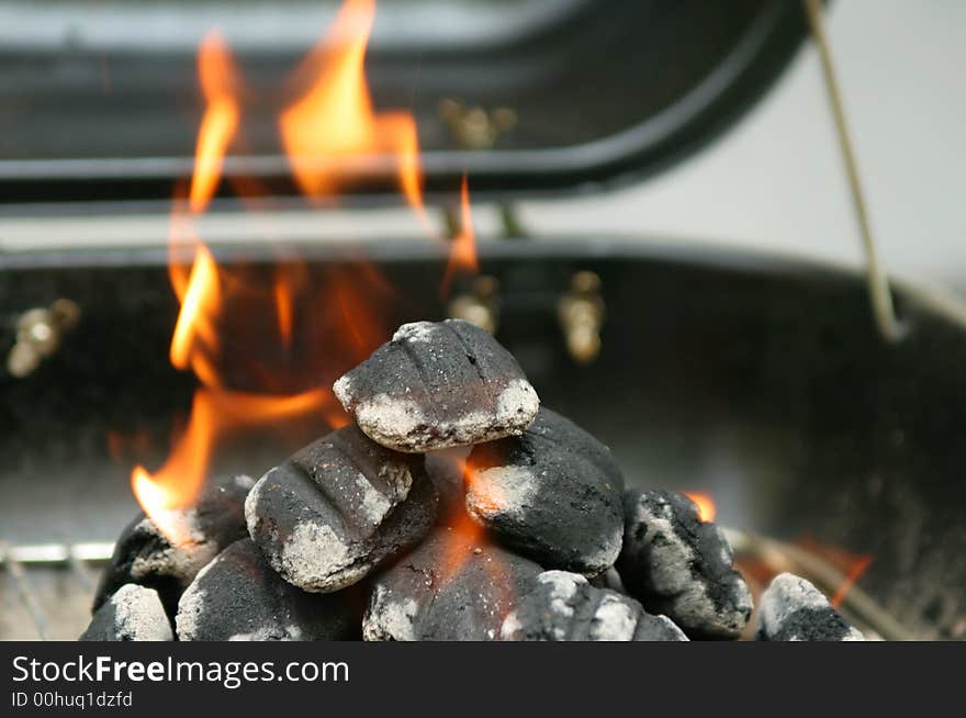 Closeup shot of charcoal briquettes burning in preparation to grill. Closeup shot of charcoal briquettes burning in preparation to grill