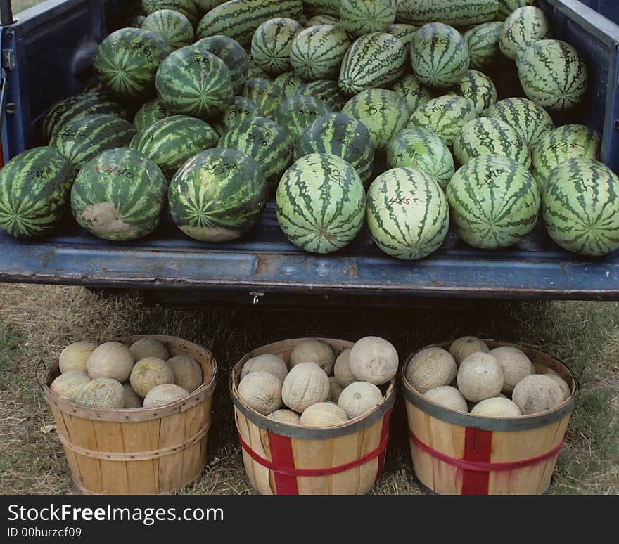 Pickup truck full of watermelons and three baskets full of cantaloupes. Pickup truck full of watermelons and three baskets full of cantaloupes