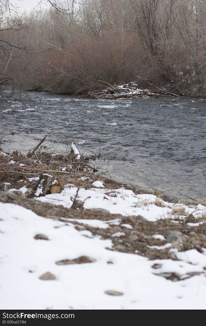 A landscape of a river scene with the snow melting on the side of the river. A landscape of a river scene with the snow melting on the side of the river