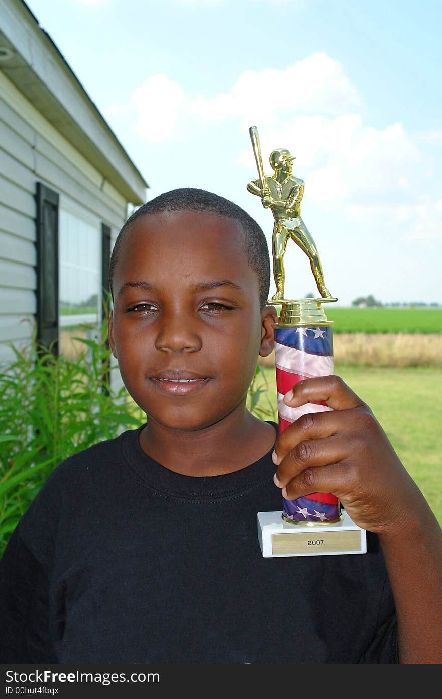 A picture of a proud boy after winning baseball trophy. A picture of a proud boy after winning baseball trophy