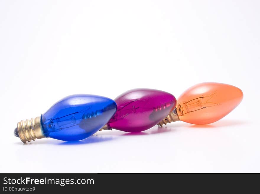 Three colored holiday light bulbs in a row. Isolated on white. Three colored holiday light bulbs in a row. Isolated on white.