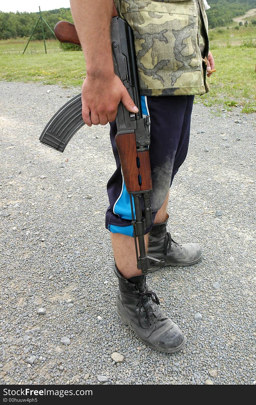 A detail of  a soldier´s legs and  a machine rifle in his hand. A detail of  a soldier´s legs and  a machine rifle in his hand