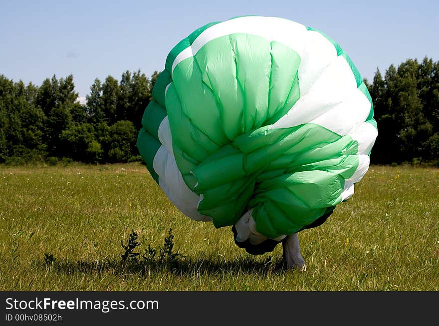 Glider on ground. Man with green wing. Glider on ground. Man with green wing.