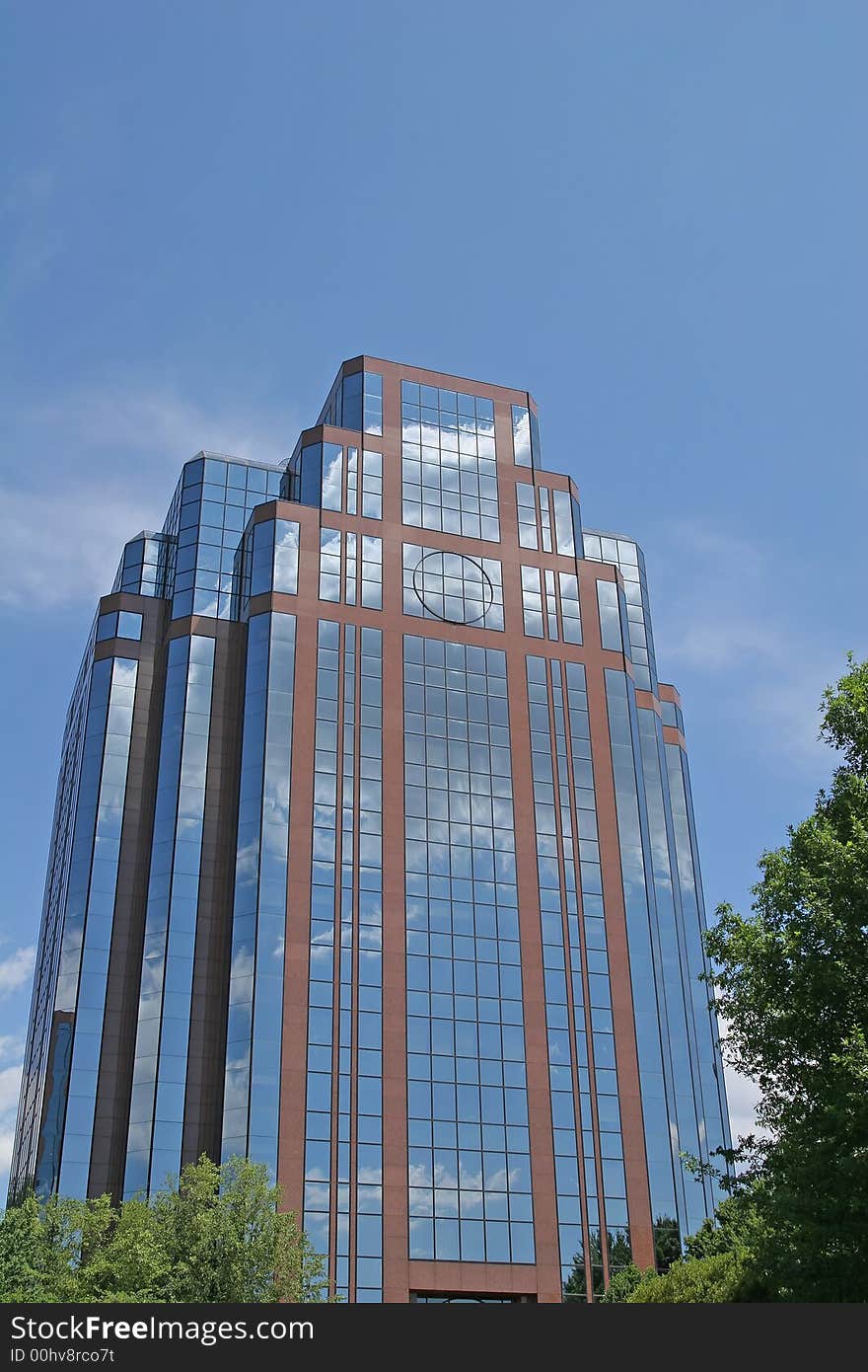 A brick and glass office building against blue sky. A brick and glass office building against blue sky