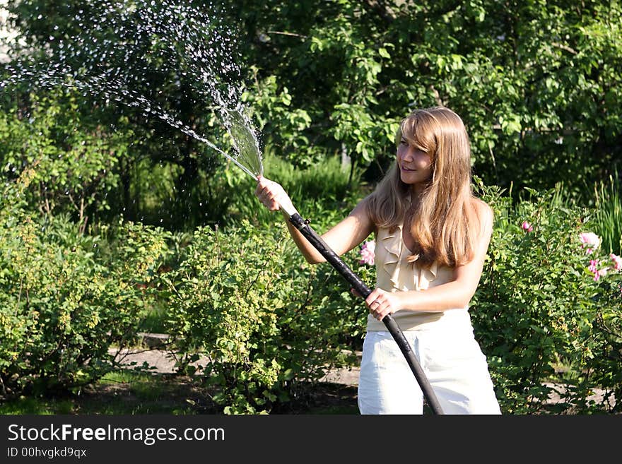 Beautiful girl in the garden with hose. Beautiful girl in the garden with hose