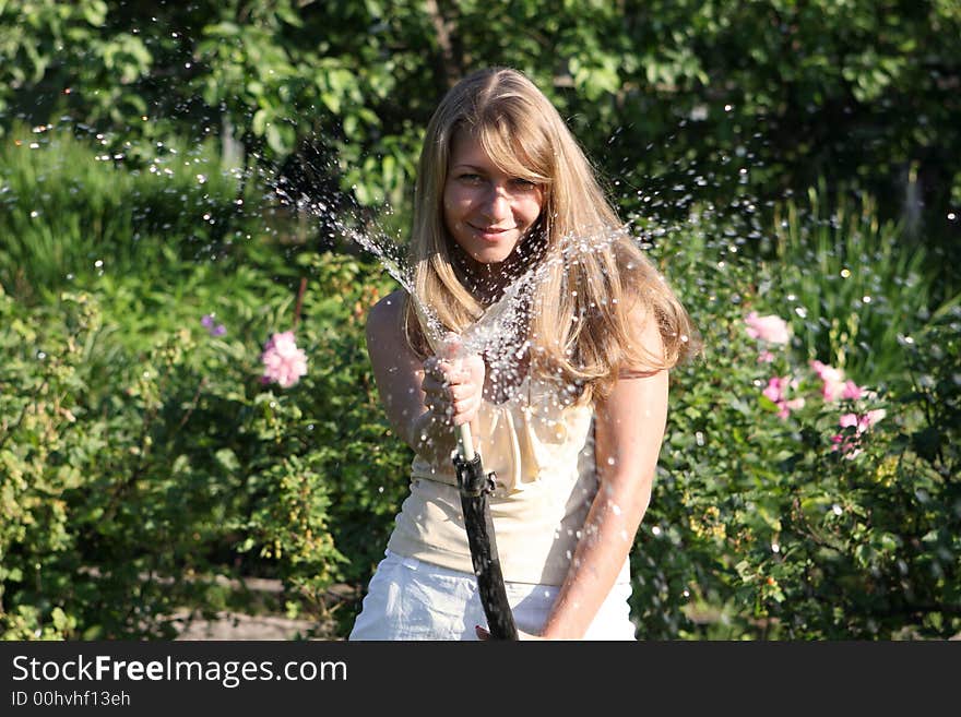 Beautiful girl in the garden with hose. Beautiful girl in the garden with hose