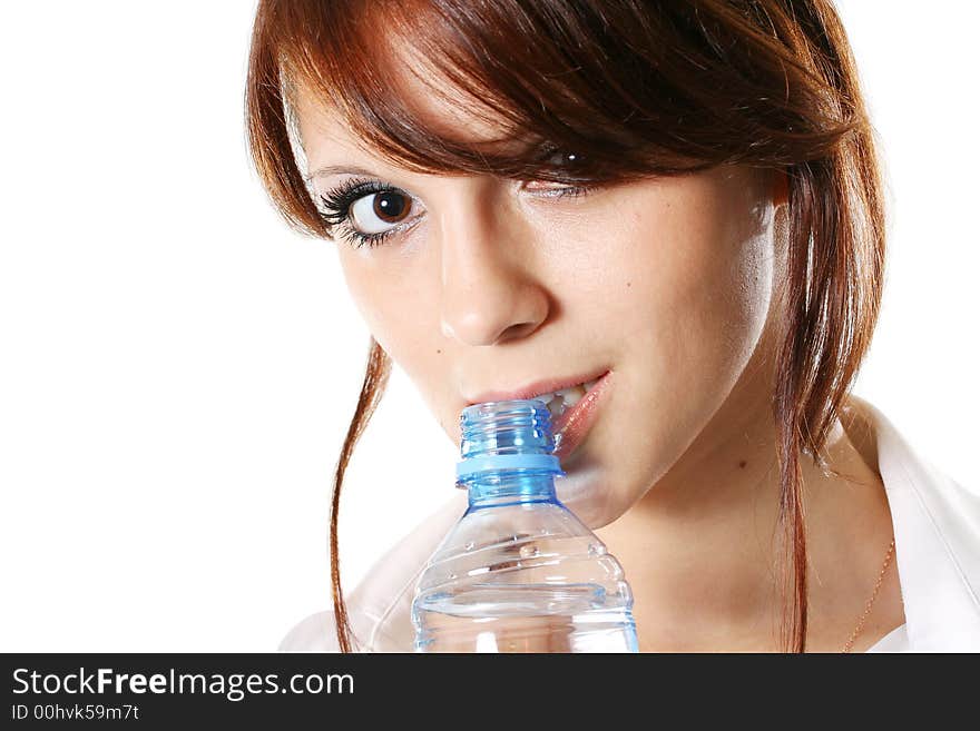 The beautiful girl drinks mineral water from a bottle. The beautiful girl drinks mineral water from a bottle