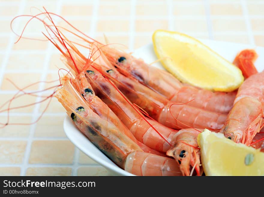 White bowl with boiled prawns and lemon slice. White bowl with boiled prawns and lemon slice