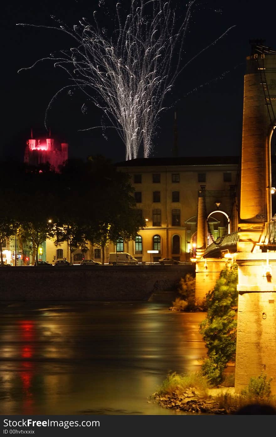 Fireworks sparkle over the basilica (Fourviere) in the city of Lyon (France) photographied from the Passerelle du college, Suspension bridge gravity-anchored over Rhone. Fireworks sparkle over the basilica (Fourviere) in the city of Lyon (France) photographied from the Passerelle du college, Suspension bridge gravity-anchored over Rhone.