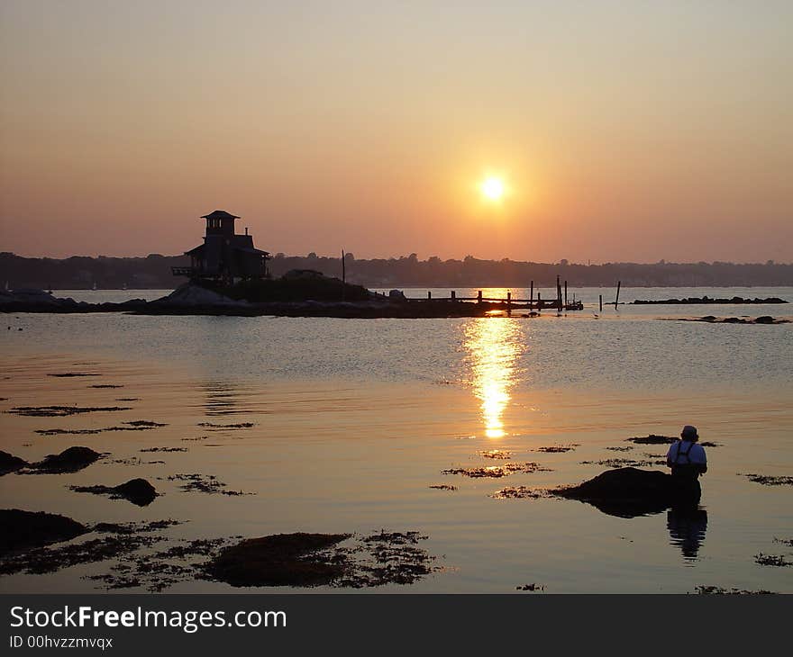 A fisherman enjoys an evening of fishing on the river. A fisherman enjoys an evening of fishing on the river.