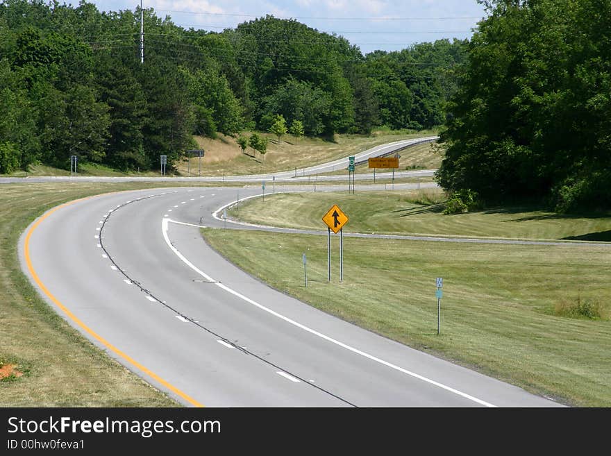 An open road with grass and trees but no cars