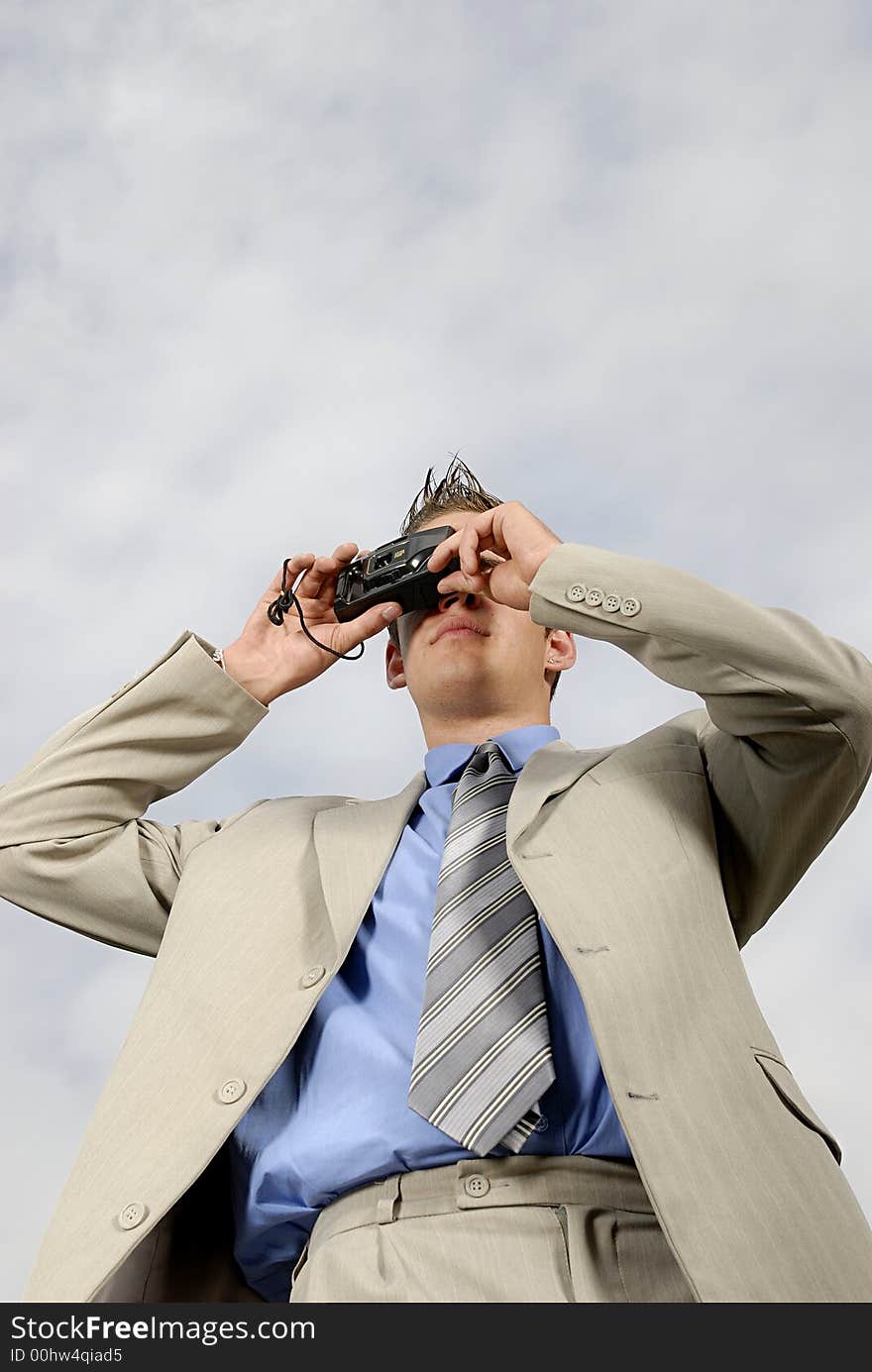 Young businessman with camera in his hands taking picture