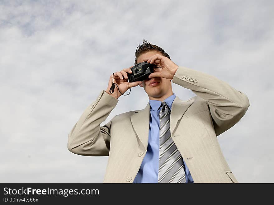 Young businessman with camera in his hands taking picture