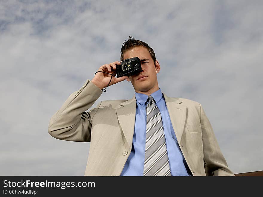 Young businessman with camera in his hands taking picture