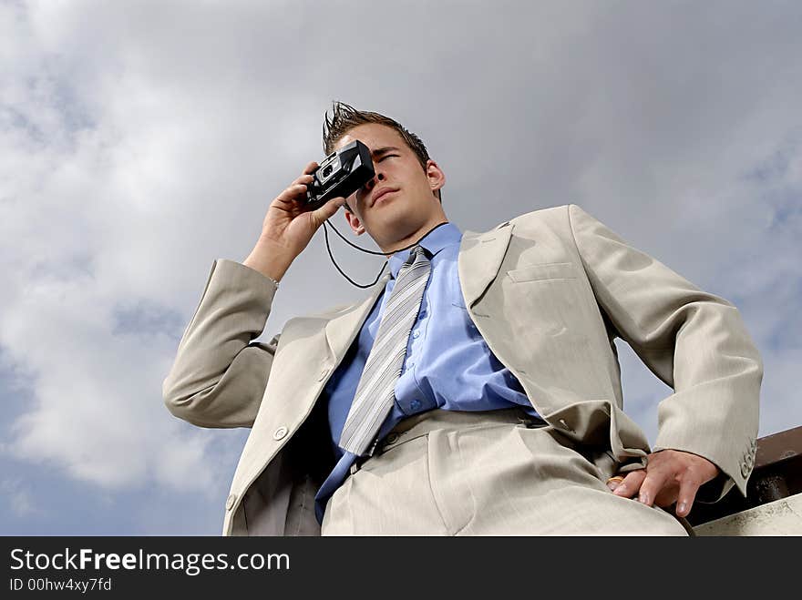 Young businessman with camera in his hands taking picture