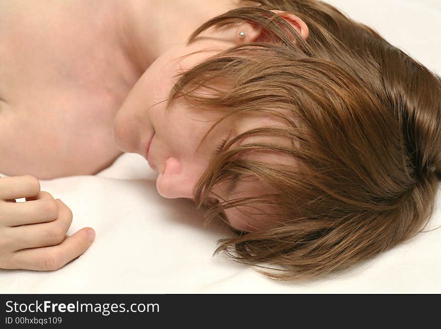 Beautiful naked young woman sleeping on white beddings, very real with messy hair, looks relaxed. Beautiful naked young woman sleeping on white beddings, very real with messy hair, looks relaxed