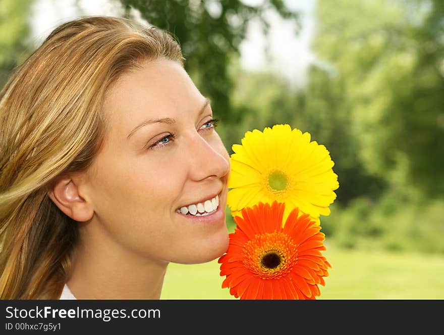 Nature portrait of a smiling young woman with two daisies. Nature portrait of a smiling young woman with two daisies