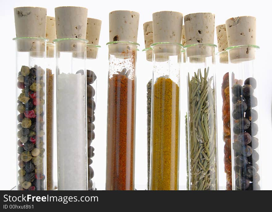 Spices in test tubes in front of a white background