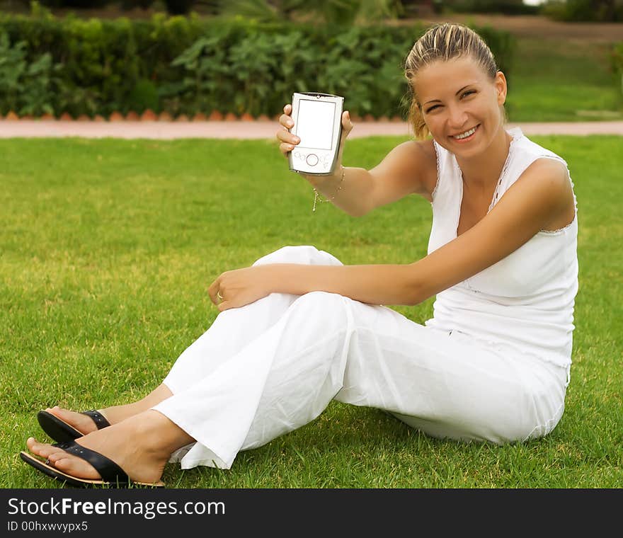 Young woman sit on a grass with PDA