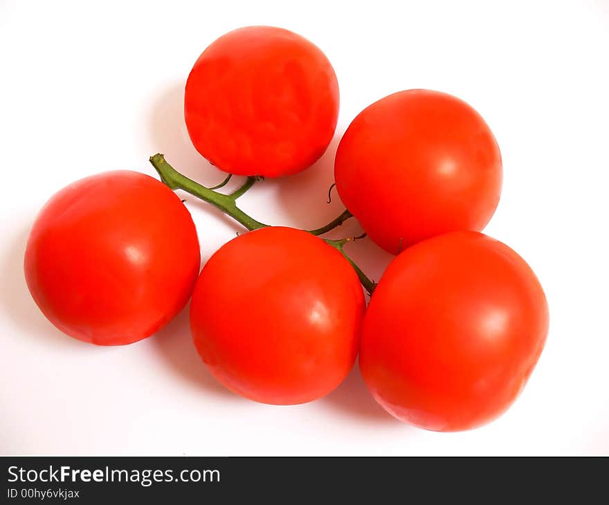 A bunch of ripe red tomatoes still together on the stem on white background.