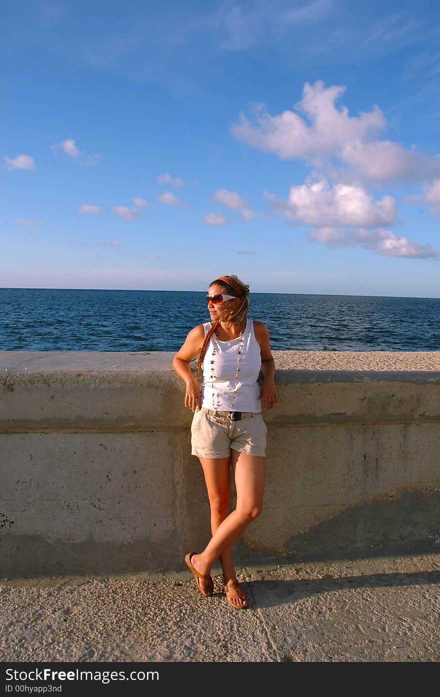 Young girl wearing sunglasses against blue sky. Young girl wearing sunglasses against blue sky