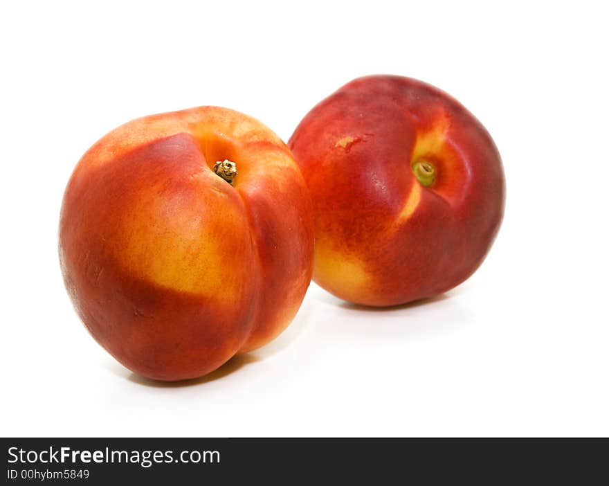 A pair of luscious sun-ripened nectarines on a white background. A pair of luscious sun-ripened nectarines on a white background