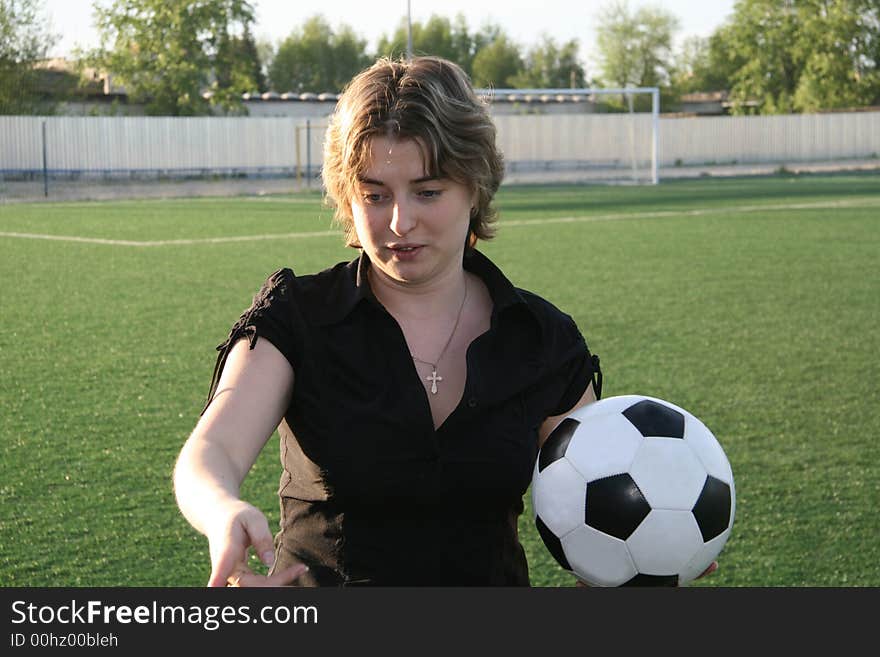 The young woman with a ball in hands gives the instruction on the organization of training on football. The young woman with a ball in hands gives the instruction on the organization of training on football