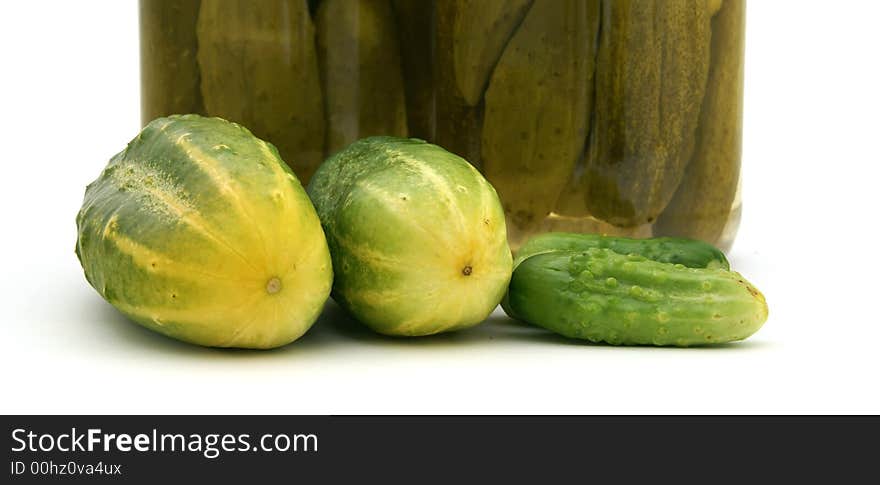 Detail of fresh cucumber with pickles in the background. Detail of fresh cucumber with pickles in the background.