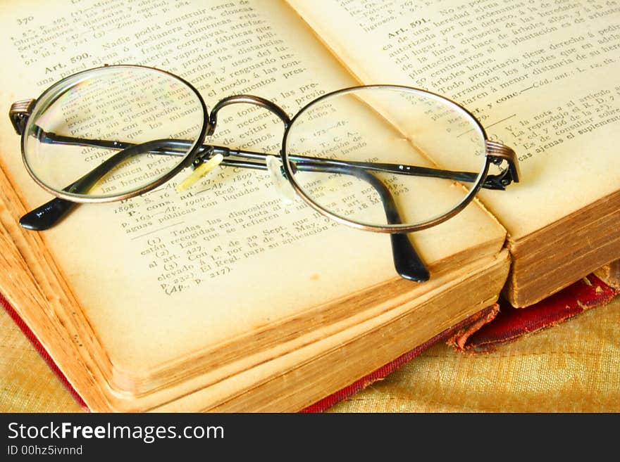 Old glasses over a vintage book of law. Old glasses over a vintage book of law