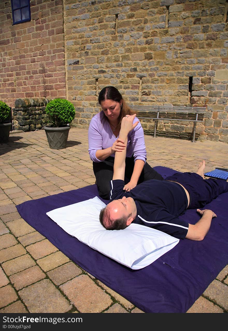 Stretching of the shoulder as part of a Thai body massage