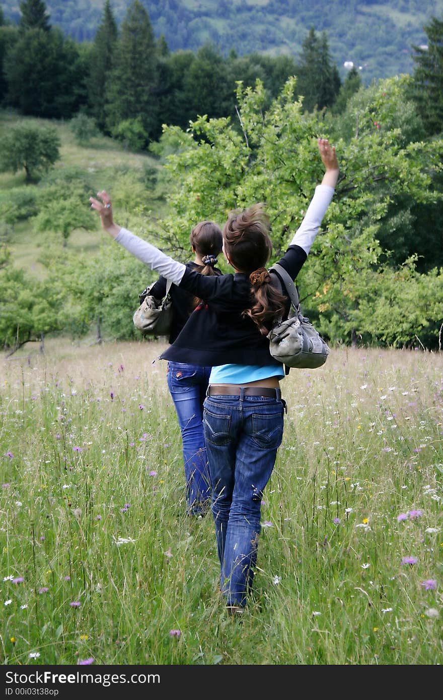 Two happy girls from the back and the forest