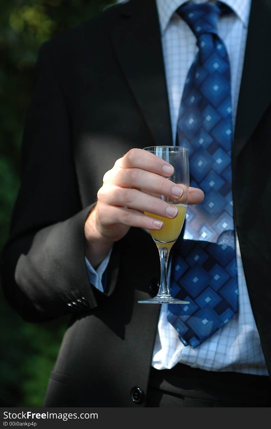 Guy in a smart suit drinking a celebration toast