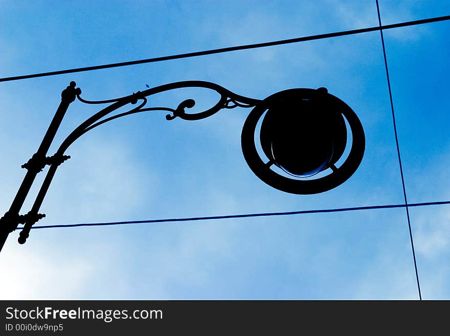 Street lamp silhouette against blue sky