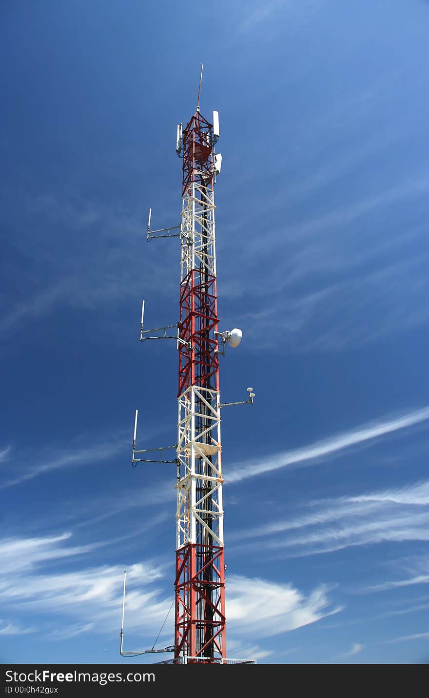 Antenna of telecomunications under a blue cloudy sky