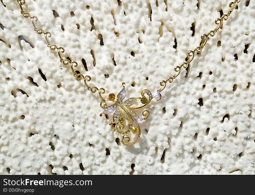 Gold necklace on a background from a sea coral