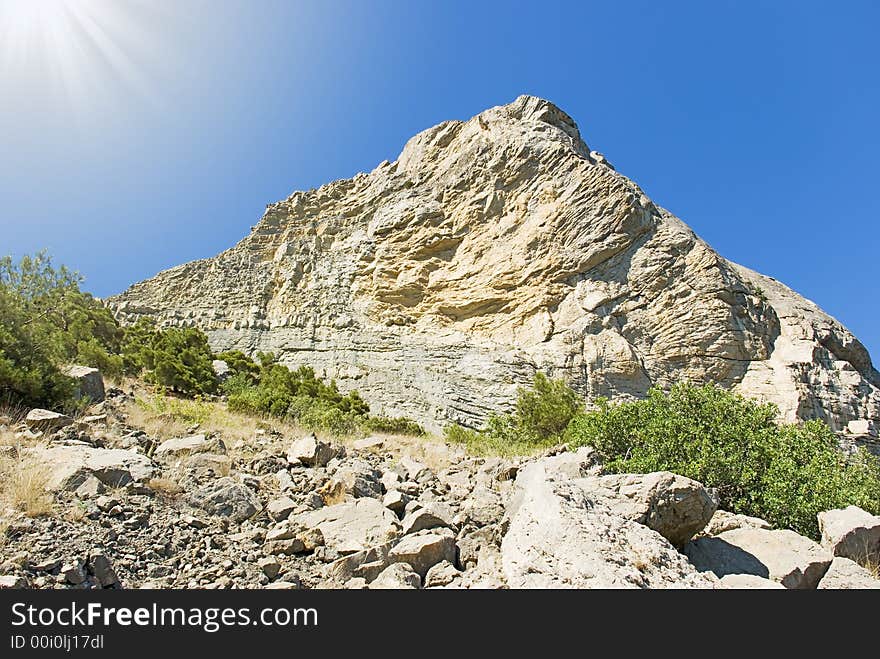 Fragment of the big rock on a background of the sated dark blue sky. Fragment of the big rock on a background of the sated dark blue sky