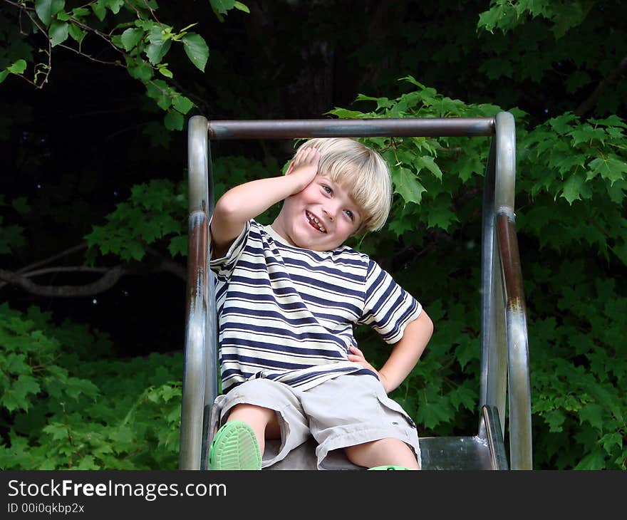 Young boy playing on slide at playground