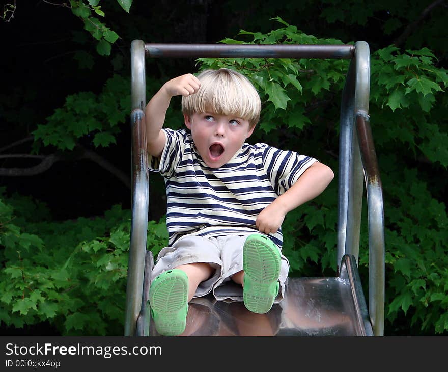 Young boy playing on slide at playground