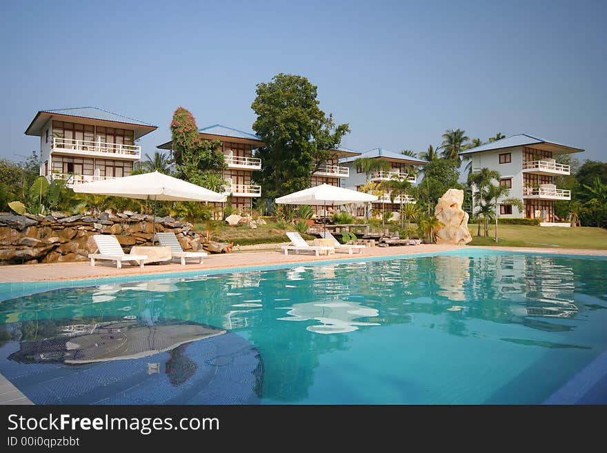 Swimming Pool With Bungalows In The Background