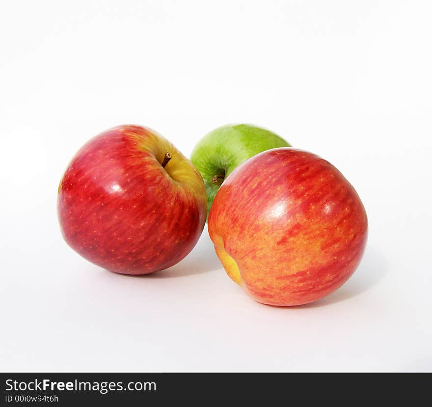 One green and two red apples on a white background. One green and two red apples on a white background.