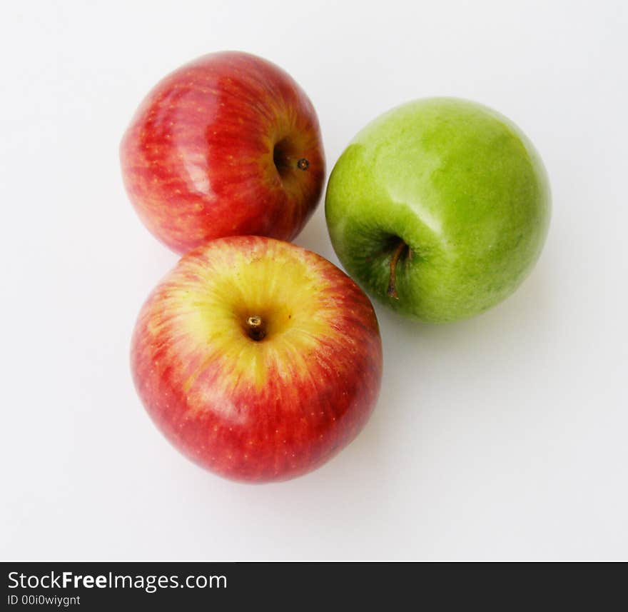 One green and two red apples on a white background. One green and two red apples on a white background.