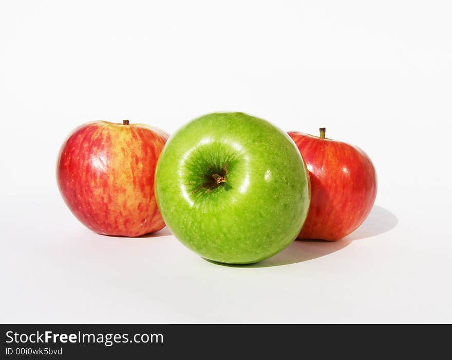 One green and two red apples on a white background. One green and two red apples on a white background.